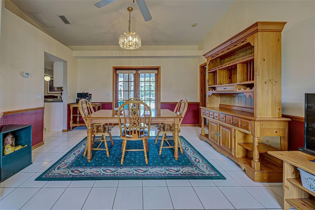 tiled dining area featuring ceiling fan with notable chandelier