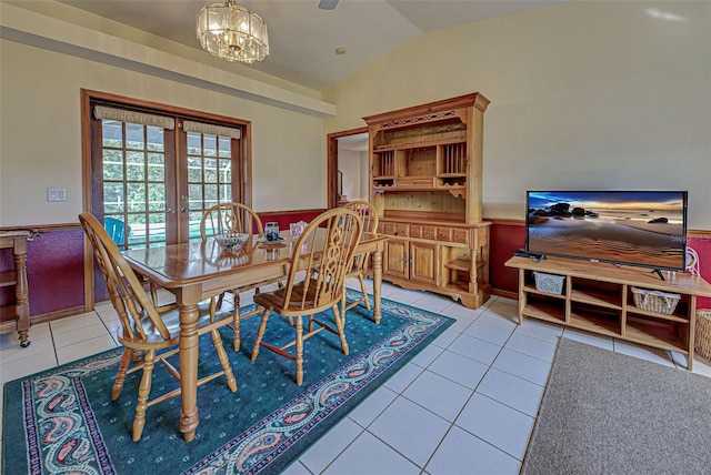 tiled dining room featuring an inviting chandelier, vaulted ceiling, and french doors