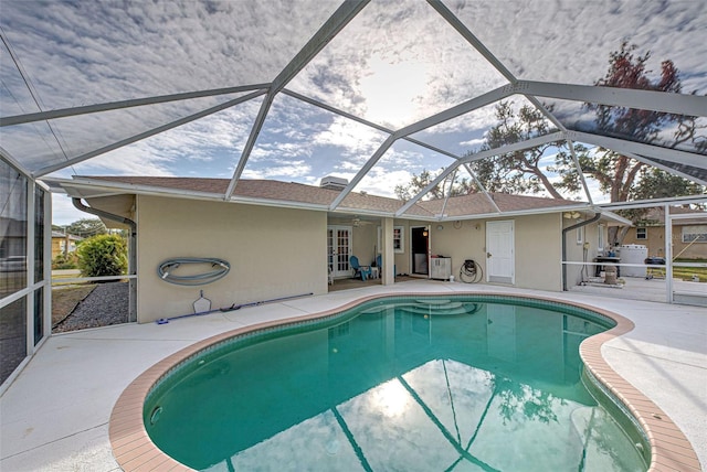 view of pool with a patio area and glass enclosure