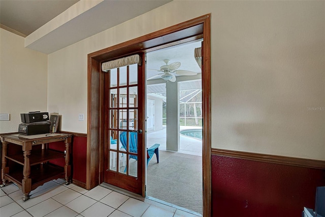 doorway with light tile patterned floors and ceiling fan