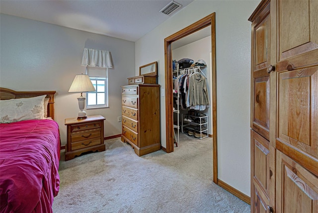 carpeted bedroom with a closet and a walk in closet