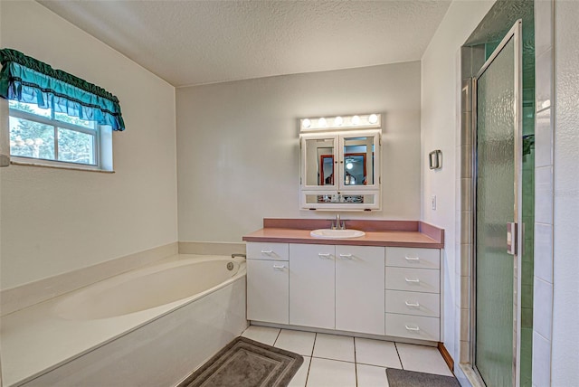 bathroom featuring independent shower and bath, vanity, a textured ceiling, and tile patterned flooring