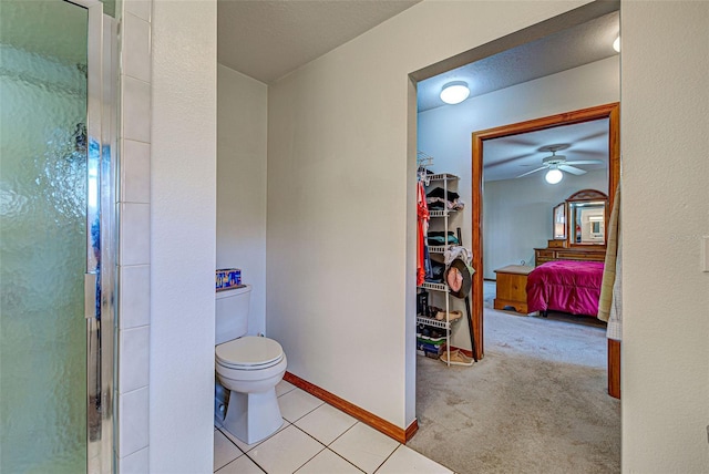 bathroom with toilet, tile patterned flooring, and a shower with shower door