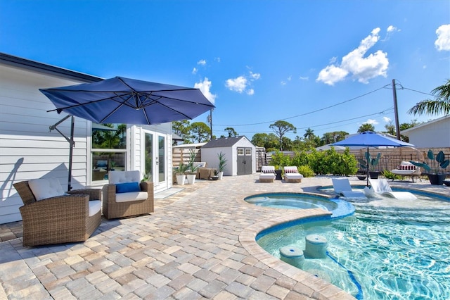 view of pool featuring a storage shed, a patio, and an in ground hot tub