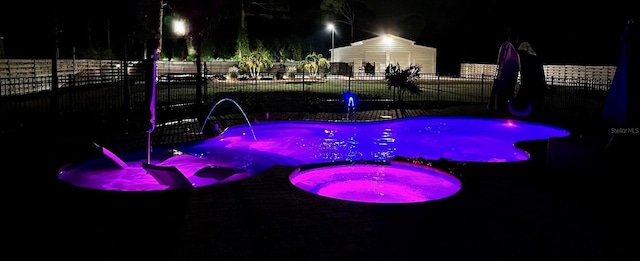 pool at night with pool water feature