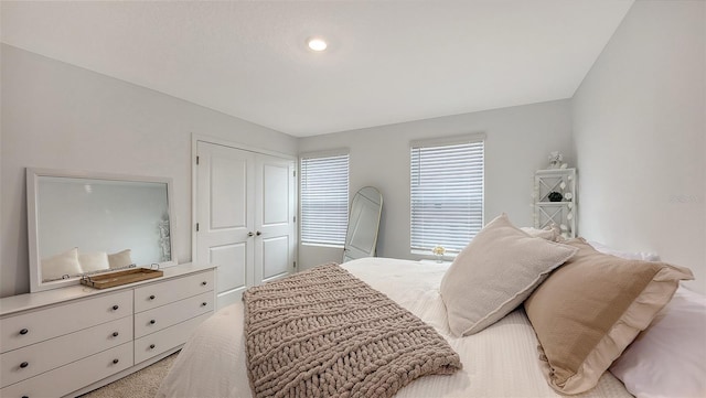 bedroom with light colored carpet and a closet