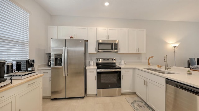 kitchen with white cabinetry, appliances with stainless steel finishes, sink, and light tile patterned floors