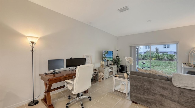 office area featuring vaulted ceiling and light tile patterned flooring