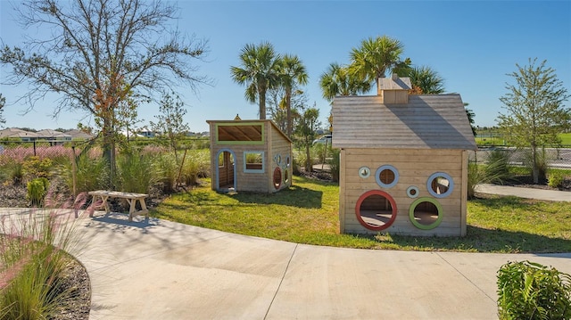 view of play area with a yard and a storage shed