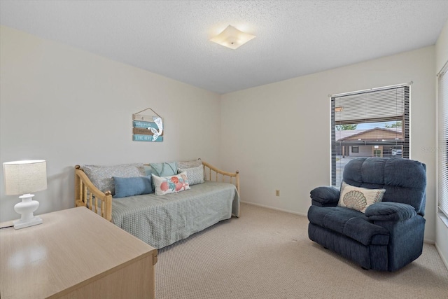 bedroom with a textured ceiling and light colored carpet