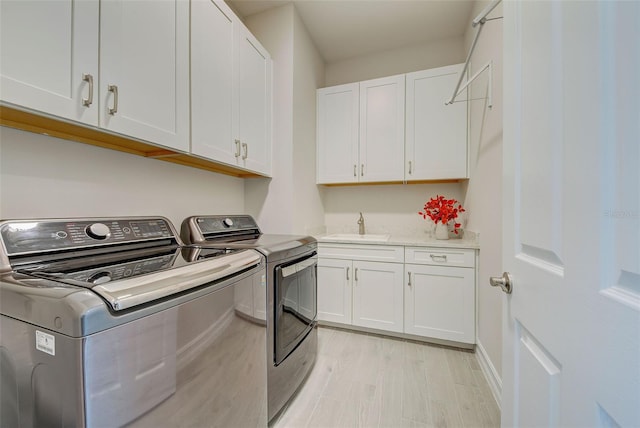 washroom featuring sink, cabinets, and washing machine and clothes dryer