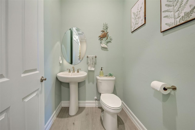 bathroom with sink, hardwood / wood-style floors, and toilet