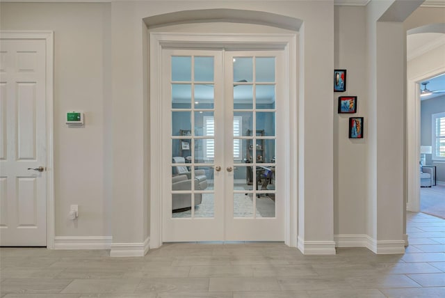 entryway featuring crown molding, light hardwood / wood-style flooring, and french doors