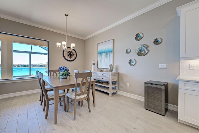 dining space featuring a water view, an inviting chandelier, light hardwood / wood-style flooring, ornamental molding, and beverage cooler