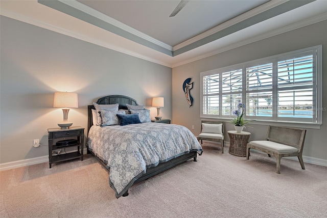 carpeted bedroom with ornamental molding, ceiling fan, and a tray ceiling