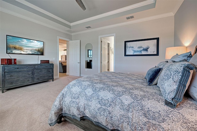 carpeted bedroom with crown molding, ceiling fan, and a tray ceiling