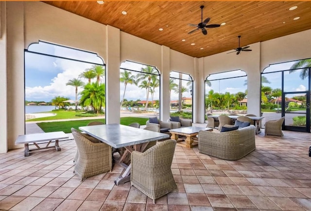 sunroom / solarium with a water view, ceiling fan, and wooden ceiling