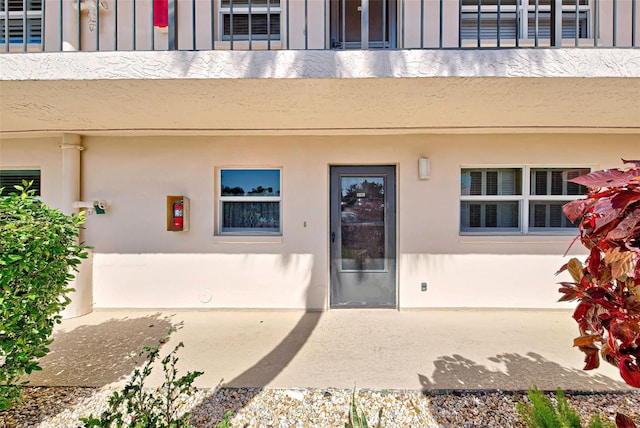 view of exterior entry with a balcony