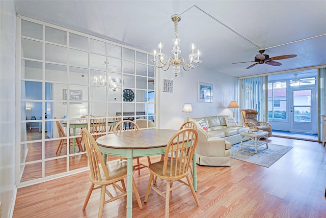 dining space featuring ceiling fan with notable chandelier, hardwood / wood-style floors, and french doors