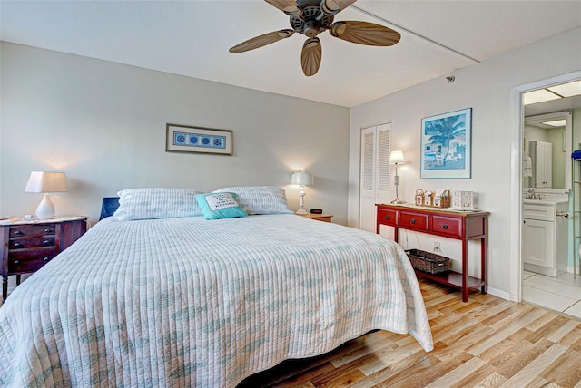 bedroom with a closet, connected bathroom, light hardwood / wood-style flooring, and ceiling fan