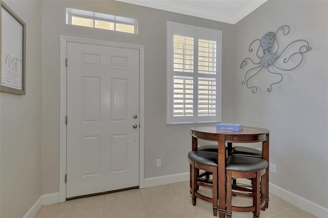 entryway with a wealth of natural light, light tile patterned floors, and ornamental molding