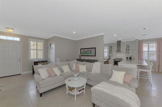 tiled living room featuring a healthy amount of sunlight, sink, and crown molding