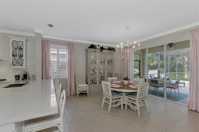 tiled dining room featuring ornamental molding, ceiling fan with notable chandelier, and sink