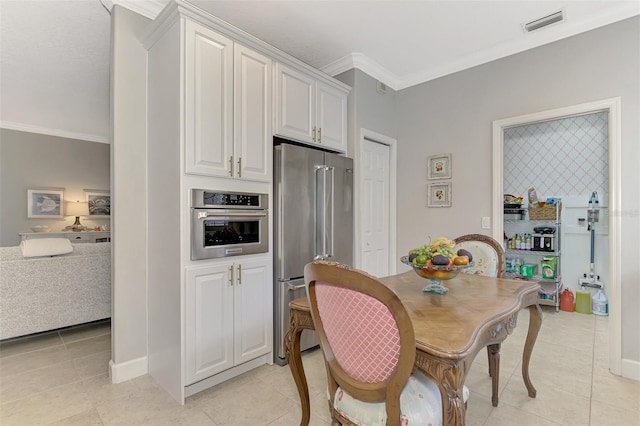 tiled dining room featuring ornamental molding