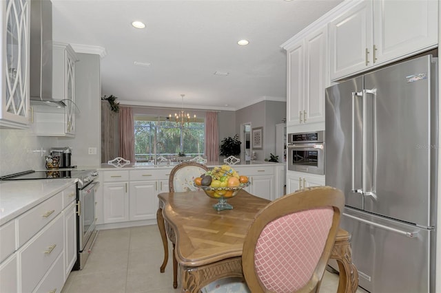 kitchen featuring white cabinets, crown molding, high end appliances, and pendant lighting