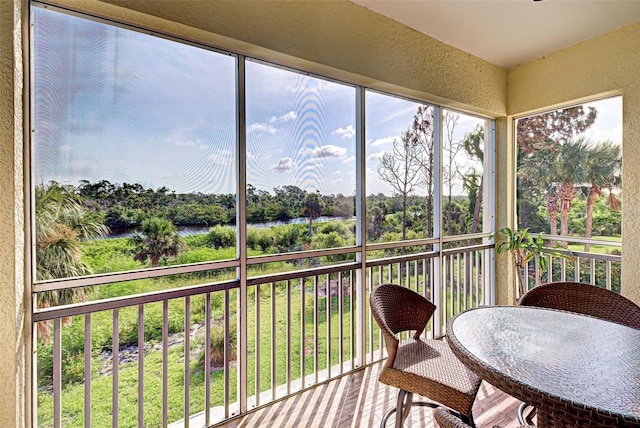 sunroom / solarium featuring a water view