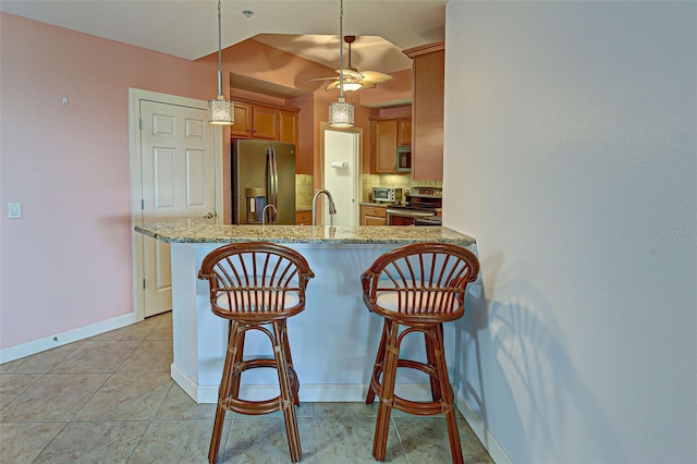 kitchen with pendant lighting, appliances with stainless steel finishes, kitchen peninsula, ceiling fan, and light stone counters