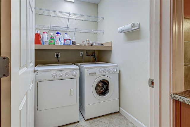 laundry room with light tile patterned floors and washing machine and clothes dryer