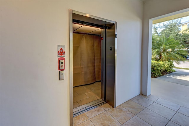 hall with light tile patterned floors and elevator