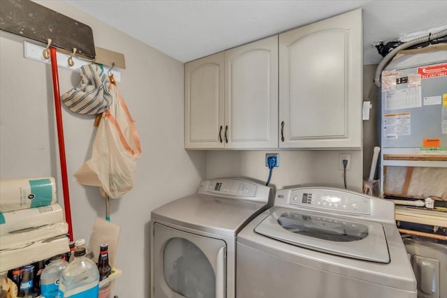 laundry area featuring washer and clothes dryer and cabinets