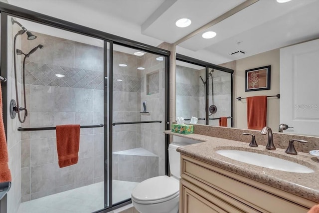 bathroom with vanity, toilet, and a shower with shower door