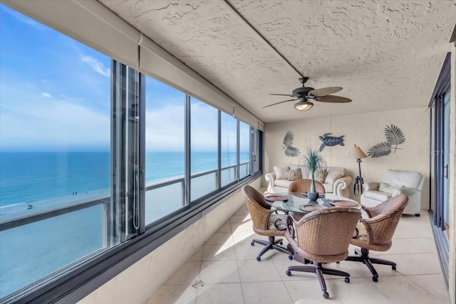 sunroom / solarium featuring a water view and ceiling fan