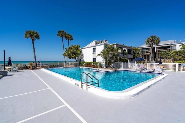 view of pool with a water view and a patio area