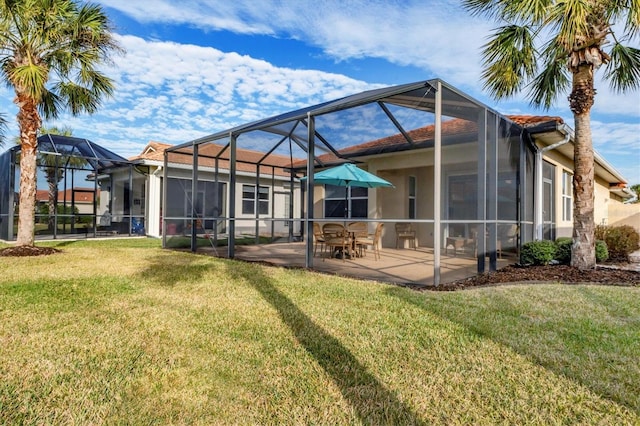 back of house featuring a patio area, glass enclosure, and a lawn