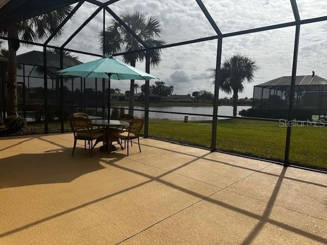 view of patio / terrace with glass enclosure and a water view