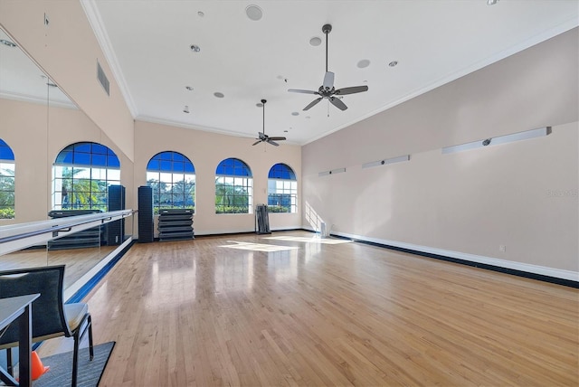 workout area with ceiling fan, ornamental molding, light wood-type flooring, and a wealth of natural light