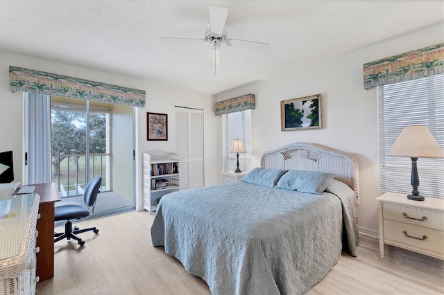 bedroom featuring a textured ceiling, multiple windows, a closet, access to outside, and ceiling fan