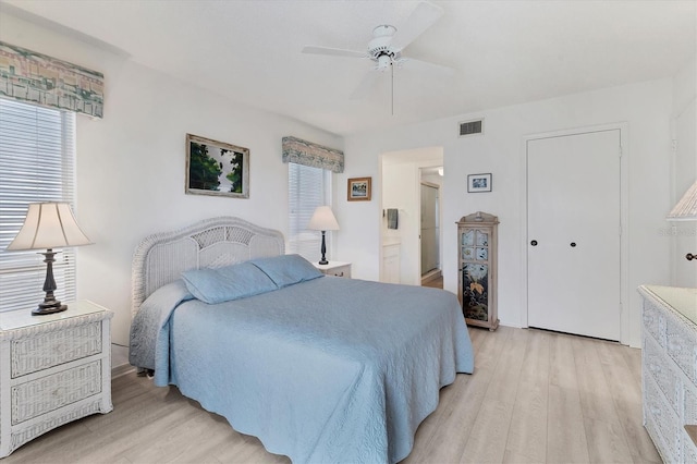 bedroom featuring ceiling fan, a closet, and light wood-type flooring