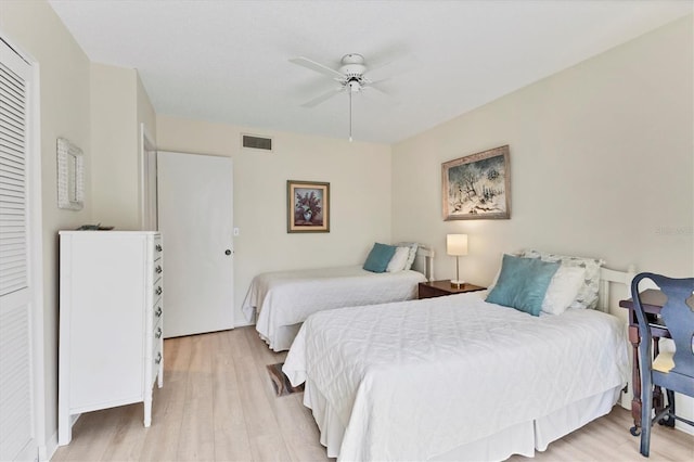 bedroom with ceiling fan, light wood-type flooring, and a closet