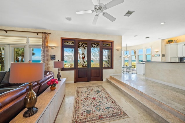 foyer entrance with ceiling fan, a wealth of natural light, and french doors