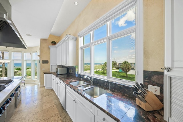 kitchen featuring sink, white cabinetry, and range hood