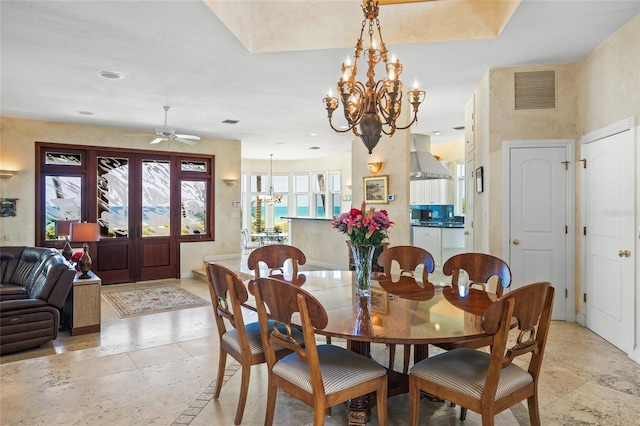 dining area with ceiling fan with notable chandelier