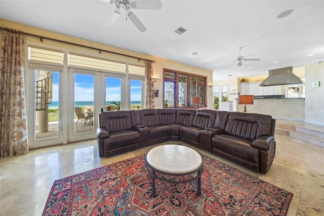 living room with a water view, ceiling fan, and french doors