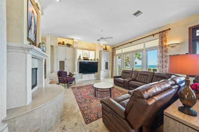 living room featuring ceiling fan, french doors, and a fireplace