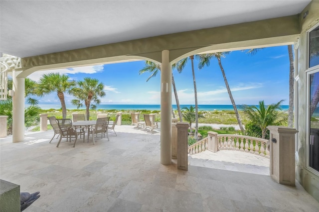 view of patio featuring a beach view and a water view