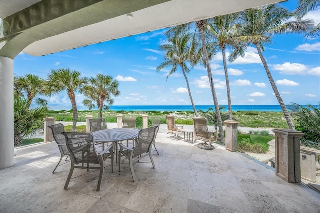 view of patio / terrace with a water view and a view of the beach